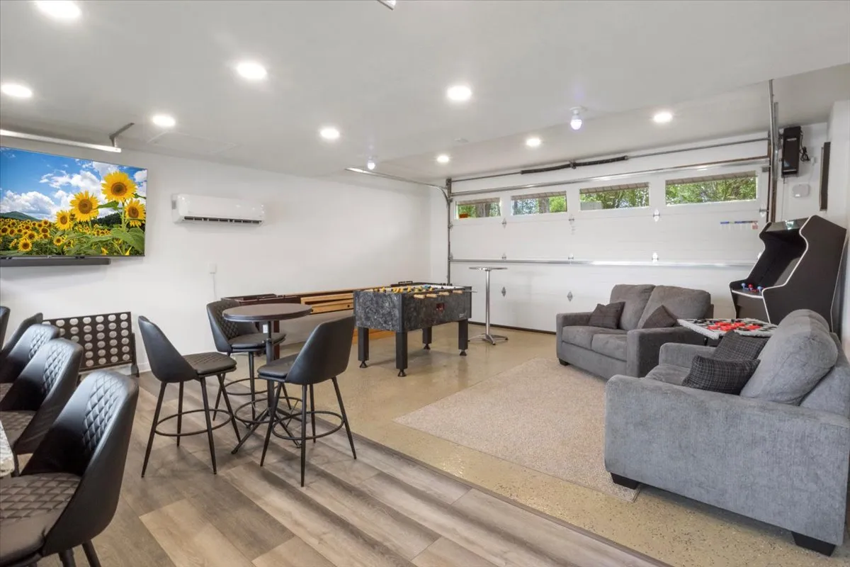 A cheerful game room with foosball table, comfortable sofa, bar seating, and a TV. The space is designed for fun, relaxation, and includes potential for a pull-out sleeper, making it ideal for extra guests or late-night gatherings.
